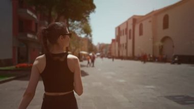 Genç ve mutlu bir bayan yazın şehir caddesinde yürüyor. Yüksek kaliteli FullHD görüntüler