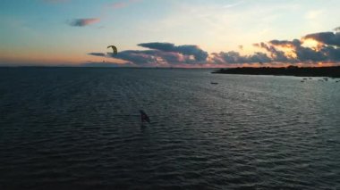 Günbatımında, Jastarnia 'da, Hel yarımadasında, hava manzaralı denizde rüzgar sörfü yapan bir adam. Yüksek kalite 4k görüntü