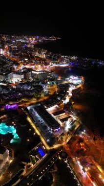 Gece şehri, aydınlık bina, otel ve aydınlık caddeler, Costa Adeje, Tenerife. Yüksek kalite 4k görüntü, hava üst görünümü, mobil görüntü için dikey görüntü