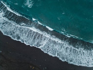 Palmiyeleri ve mavi suları olan güzel siyah volkanik kumlu plaj, Puerto de la Cruz, Tenerife, Kanarya adası, gökyüzü manzaralı. Yüksek kaliteli resim