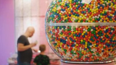 Baba ve oğul şeker dükkanından şeker ve sakız alıyor. Yüksek kalite 4k görüntü