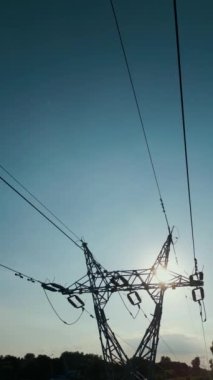 Mavi gökyüzü arka planında yüksek voltajlı elektrik hattı, elektrik iletimi. Yüksek kalite 4k görüntü, hava üst görünümü, dikey video