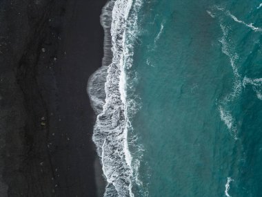 Palmiyeleri ve mavi suları olan güzel siyah volkanik kumlu plaj, Puerto de la Cruz, Tenerife, Kanarya adası, gökyüzü manzaralı. Yüksek kaliteli resim