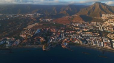 Okyanus kıyısında mavi su, sahil ve oteller, güneyde Tenerife, Kanarya adası. Yüksek kaliteli hava aracı görüntüsü 4k