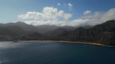Playa De Las Teresitas mavi okyanusu ve Tenerife 'deki Anaga ulusal parkının dağı. Yüksek kalite 4K hava aracı görüntüsü