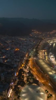 Santa Cruz de Tenerife, Kanarya 'nın ışıklı caddeleri ile gece şehir manzarası. Yüksek kaliteli dikey video görüntüleri