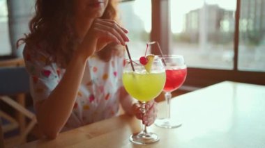 Genç ve güzel bir kadın restoranda alkollü içecek içiyor.