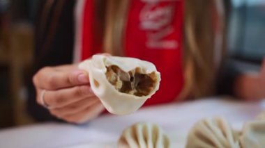 İnsan, khinkali köftesini et veya mantarla ısırır. Yüksek kaliteli FullHD görüntüler