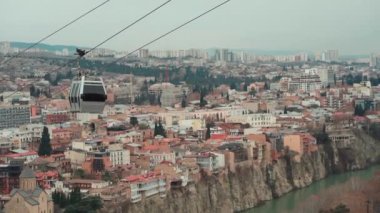 Gürcistan 'ın başkenti Tiflis üzerinde teleferik halatı, tarihi bölgenin havadan görünüşü. Yüksek kaliteli FullHD görüntüler