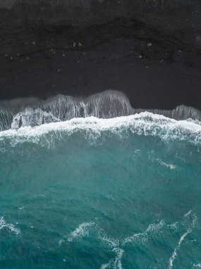 Palmiyeleri ve mavi suları olan güzel siyah volkanik kumlu plaj, Puerto de la Cruz, Tenerife, Kanarya adası, gökyüzü manzaralı. Yüksek kaliteli resim
