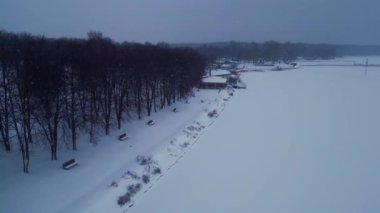 Donmuş kış gölünde kar yağışı, karlı beyaz su manzarası, kar mevsimi ve kar fırtınası havası manzarası. Yüksek kalite 4k görüntü