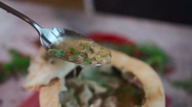 İnsan biftek, domuz ya da kuzu eti ve khinkali çorbası yer. Yanında da kase ile birlikte nefis hamurdan yapılmış ekmek, yakın plan. Yüksek kaliteli FullHD görüntüler