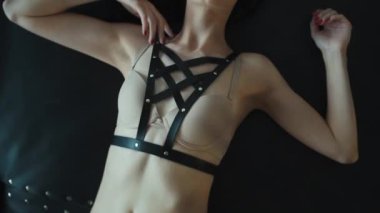 Siyah deri kemer ve esaret altında dans eden seksi çıplak striptizci kadın, baştan çıkarıcı iç çamaşırlarıyla şehvetli striptizci kadın dansçı, seks rol yapma. Yüksek kaliteli FullHD görüntüler