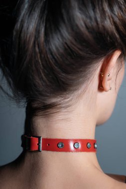 Metalik yüzüklü kırmızı deri bdsm yakalı genç bir kadın baştan çıkarıcı rol yapan seksi boğucu kadın. Yüksek kalite fotoğraf