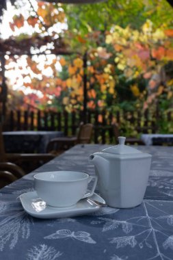 Parkın dışındaki masada fincanlı çaydanlık, gün batımında taze kahvaltı. Yüksek kalite fotoğraf
