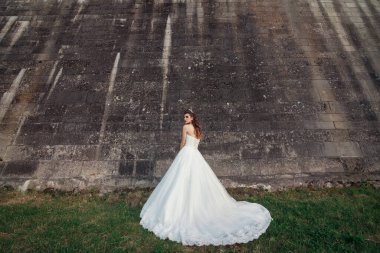 Güzel, şık bir gelin manken kız eski şatoda poz veriyor, düğün fotoğrafı çekiliyor.