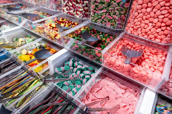 showcase of candy shop, transparent container with various sweets, marshmallow, jelly, chewy gums, rich sugar assortment. High quality photo