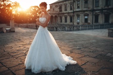 Güzel, şık bir gelin manken kız eski şatoda poz veriyor, düğün fotoğrafı çekiliyor.