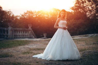 Güzel, şık bir gelin manken kız eski şatoda poz veriyor, düğün fotoğrafı çekiliyor.