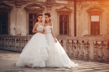 Modellik yapan iki şık gelin eski şatoda poz verir, düğün fotoğrafı çeker.