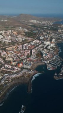 Okyanus kıyısı, yat ve tekne limanı Costa Adeje, Tenerife, Canary 'nin mavi suları. Yüksek kalite 4K hava görüntüsü, hikayeler ve makaralar için dikey