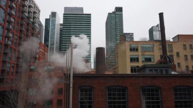 New York ya da Toronto 'da buharlı baca borusu, şehirli gökdelenler üzerine duman yığını. Yüksek kalite 4k görüntü