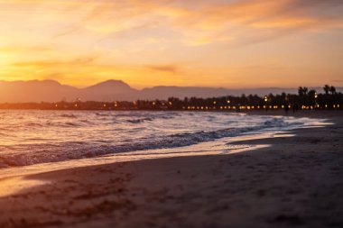 Sakin denizin üzerinde güzel bir gün batımı, su dalgaları ve temiz kum, Salou, İspanya. Yüksek kalite fotoğraf