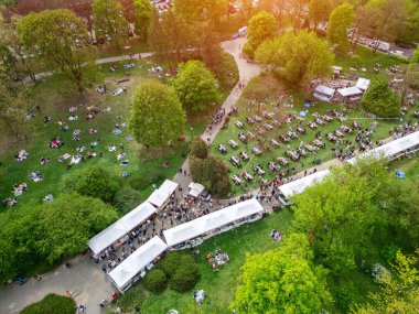 Yazın Green Park 'ta şehir sokak yemekleri festivali, yeşil çayırlarda gıda çadırı, piknikte kalabalık yürüyüşü ve oturma, hava manzarası. Yüksek kalite fotoğraf