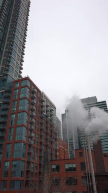 New York ya da Toronto 'da buharlı baca borusu, şehirli gökdelenler üzerine duman yığını. Yüksek kalite 4k görüntü