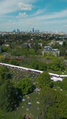 Yazın Green Park 'ta şehir sokak yemekleri festivali, yeşil çayırlarda gıda çadırı, piknikte kalabalık yürüyüşü ve oturma, hava manzarası 4k. Yüksek kaliteli görüntüler, dikey video