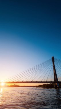 Günbatımında Vistula Nehri üzerinde modern kablo köprüsü, Varşova 'nın çağdaş yapıları, arka planda mavi gökyüzü. Yüksek kalite fotoğraf