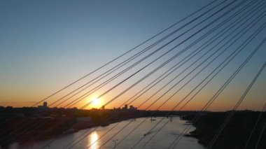 Günbatımında Vistula Nehri üzerinde modern kablo köprüsü, Varşova 'nın çağdaş yapıları, arka planda mavi gökyüzü. Yüksek kalite 4k görüntü