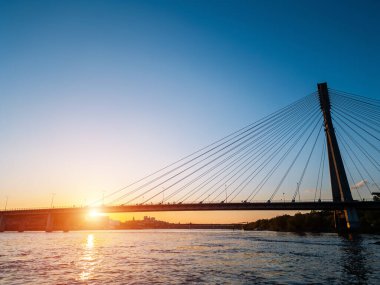 Günbatımında Vistula Nehri üzerinde modern kablo köprüsü, Varşova 'nın çağdaş yapıları, arka planda mavi gökyüzü. Yüksek kalite fotoğraf