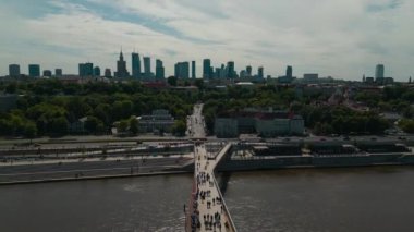 Günbatımında Vistula nehri üzerinde yeni inşa edilmiş yaya ve bisiklet modern köprüsü, şehir merkezindeki finans bölgesi ve Varşova şehrinin modern mimarisi, gökyüzü manzarası 4k. Yüksek kaliteli görüntüler