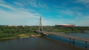 PGE Narodowy Stadyumu ve günbatımında Vistula Nehri üzerindeki modern kablo köprüsü, Varşova 'nın çağdaş yapıları, arka planda mavi gökyüzü. Yüksek kalite 4k görüntü