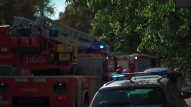 İtfaiyeciler ve polis acil durum çağrılarına, merdivenli itfaiye araçlarına ve yanıp sönen mavi ışıklara cevap veriyor. İtfaiyeciler ekipmanları yerleşim alanında hazırlayın. Yüksek kalite 4k görüntü