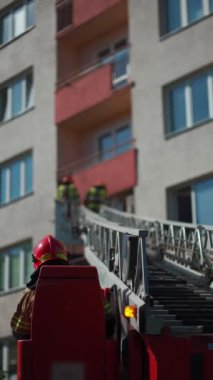 Genişletilmiş merdiveni olan itfaiye aracı konut binasına ulaşır, itfaiyeciler balkonda koruyucu teçhizat ile çalışırlar, acil durum müdahalesi yaparlar, dikey video çekerler. Yüksek kalite 4k görüntü