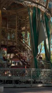 Mutlu çocuklarla dolu renkli bir atlıkarınca lunaparktaki antika kavşağında neşeli çocuklar, dikey video görüntüleri. Yüksek kalite 4k görüntü