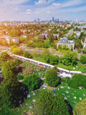 Yaz mevsiminde Green Park 'ta şehir yemekleri festivali, yeşil çayırlarda gıda çadırı, Varşova' da piknikte kalabalık yürüyüşü ve oturma, hava manzarası. Yüksek kalite fotoğraf