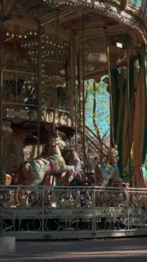 Mutlu çocuklarla dolu renkli bir atlıkarınca lunaparktaki antika kavşağında neşeli çocuklar, dikey video görüntüleri. Yüksek kalite 4k görüntü