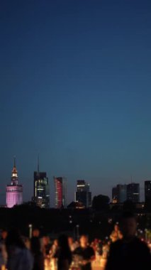 Varşova şehrinin gökdelenleri ve şehir merkezli silueti üzerinde bir gece. Yürüyen insan kalabalığı, turist gezileri, Polonya 'nın yoğun saatleri, dikey videolar. Yüksek kaliteli görüntüler