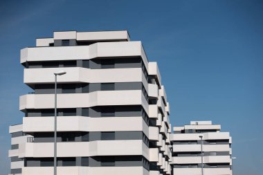 Şehir ortamında açık mavi gökyüzüne karşı eşsiz bir tasarımı olan modern banliyö mimari binaları. Yüksek kalite fotoğraf