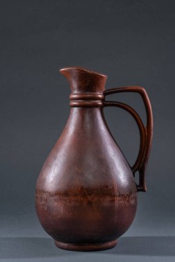 Tarafsız bir arkaplanda seramik sanatında geleneksel çömlekçilik teknikleri ve zanaatkarlık sergileyen el yapımı toprak sürahisi. Yüksek kalite fotoğraf