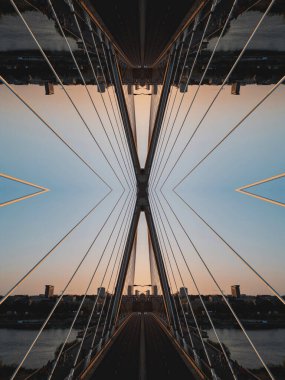 Karmaşık aynalı geometrik çizgiler ve şekiller simetrik bir şablon içinde birleşerek yüksek teknolojili soyut bir estetiği canlı bir günbatımı siluetine karşı yakalıyor. Yüksek kalite fotoğraf