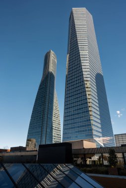Gündüz saatlerinde, kentsel alanda, Cuatro Torres ve Madrid şehir merkezinde, modern gökdelen kuleleri açık mavi gökyüzüne karşı yükseliyor. Yüksek kalite fotoğraf