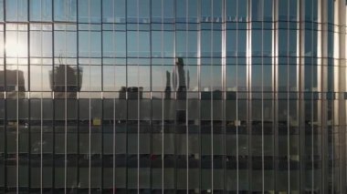 Modern ofis binasının dışında camdan ve çelikten aynalarda şehir yansıması, finansal bölgenin çağdaş mimarisi. Yüksek kalite 4k görüntü
