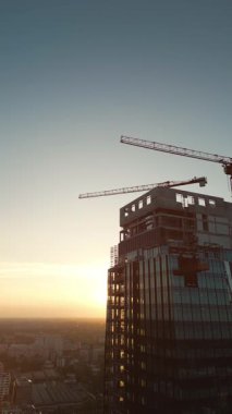 Cam ve çelikten yapılmış modern ofis gökdelen binası inşaat alanı endüstrisi, hava aracı görüntüsü 4K. Yüksek kaliteli görüntüler, dikey video