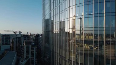 Modern ofis binasının dışında camdan ve çelikten aynalarda şehir yansıması, finansal bölgenin çağdaş mimarisi. Yüksek kalite 4k görüntü