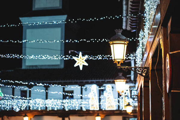 Рождественский уличный декор с подсветкой и уютными фонарями ночью, празднованием Нового года и украшениями. Высокое качество фото