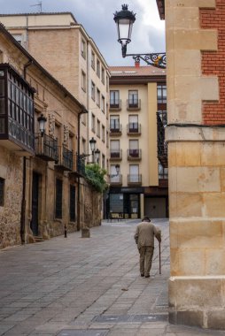 Bulutlu bir günde İspanyol kasabası Soria 'da bastonlu yaşlı bir adam tarihi caddede yürüyor. Yüksek kalite fotoğraf